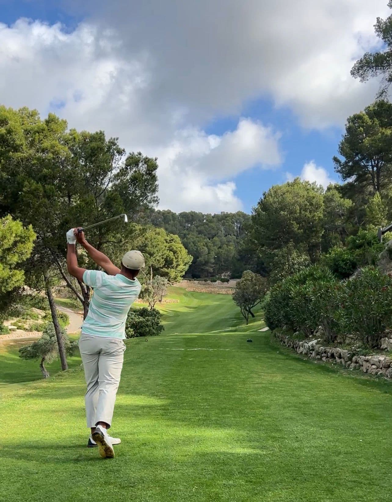 Tee shot on hole 7 at Golf de Andratx with stone walls in front of the green