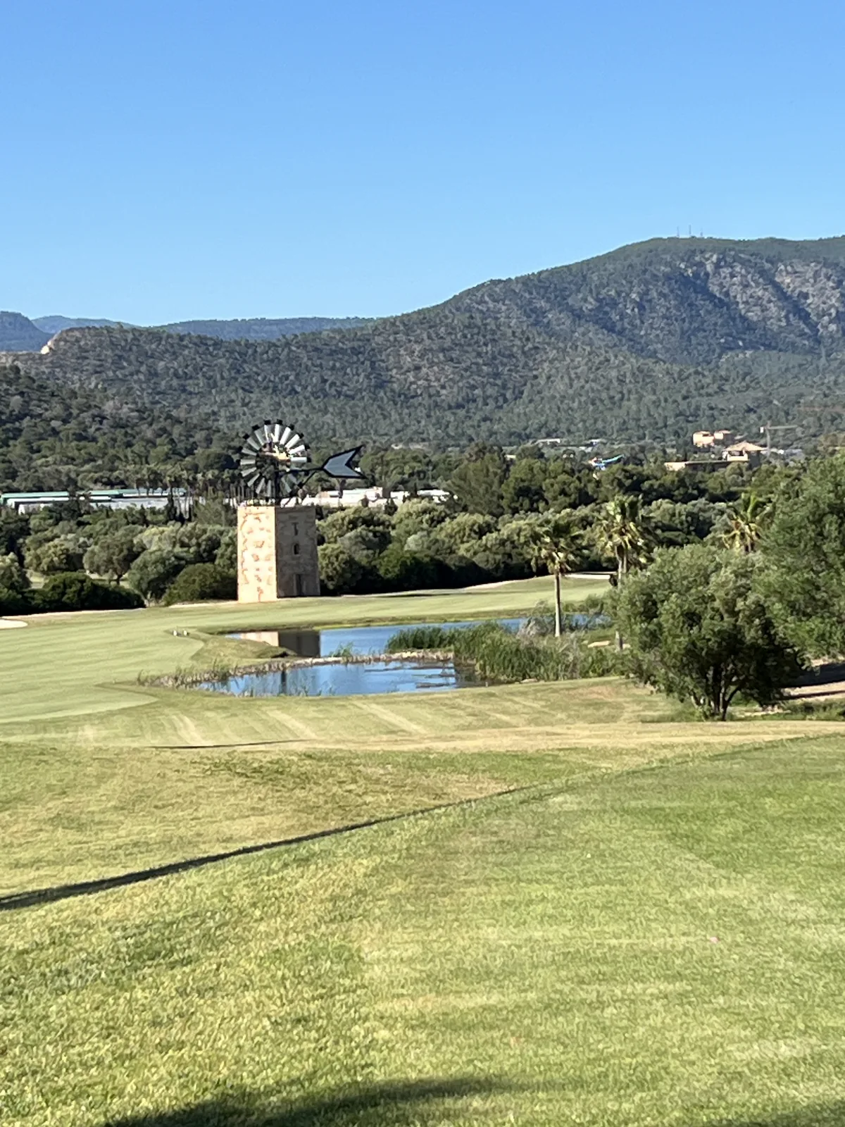 Fairway at T Golf Calvià with windmill and Tramuntana mountains in the background